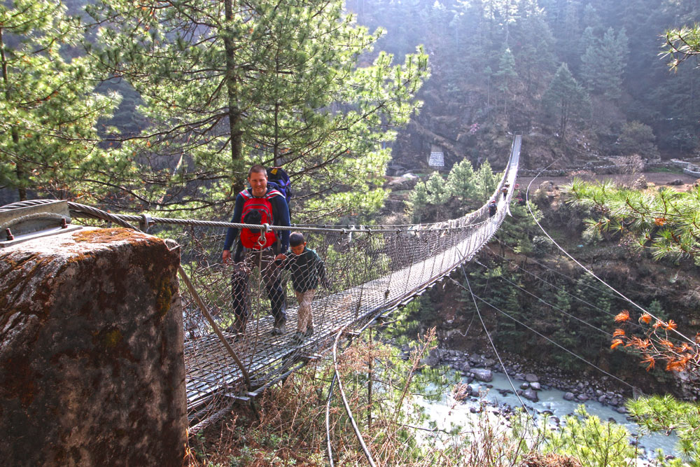 Trekking over a suspension bridge along the Everest Base Camp trek distance.